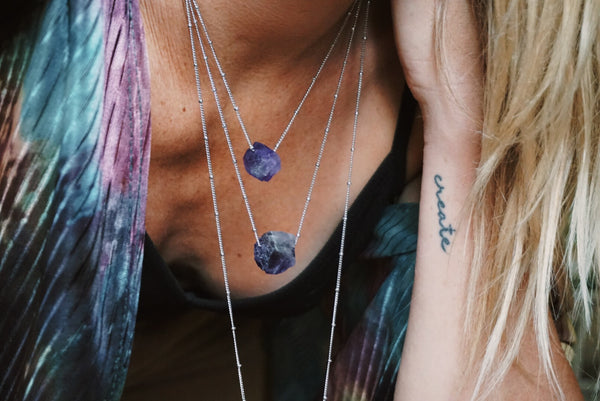 variety of raw amethyst chunks held by silver chain, product image