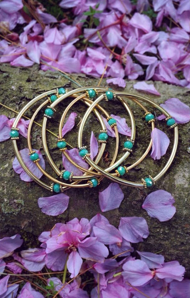 stretchy, gold tube bar bracelets, green beads in between
