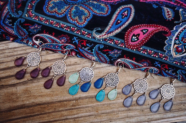 variety of silver earrings with different color glass drops suspended