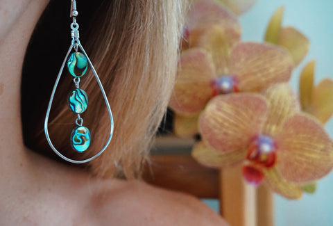 Sirena Scales earring, 3 tiered abalone ovals in silver teardrop hoop, on model