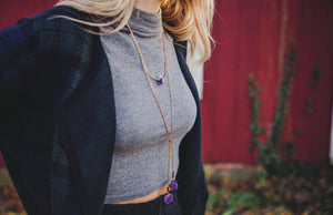gold lariat necklace accented with raw amethyst, product on model