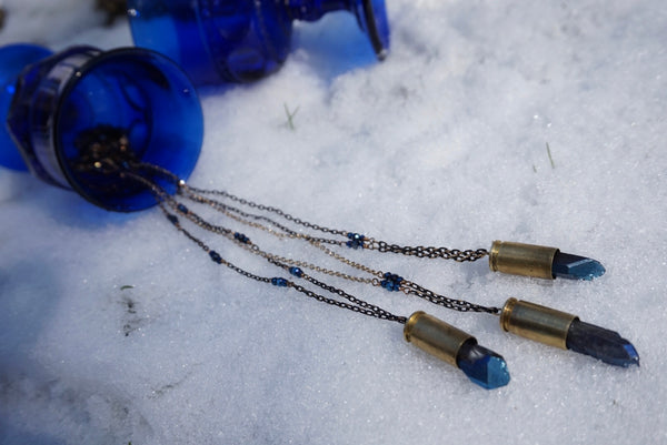 blue crystals, bullet necklaces, on black and gold chain, on snow