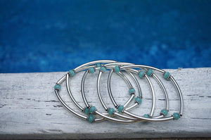 stretchy, silver tube bar bracelets, turquoise beads in between