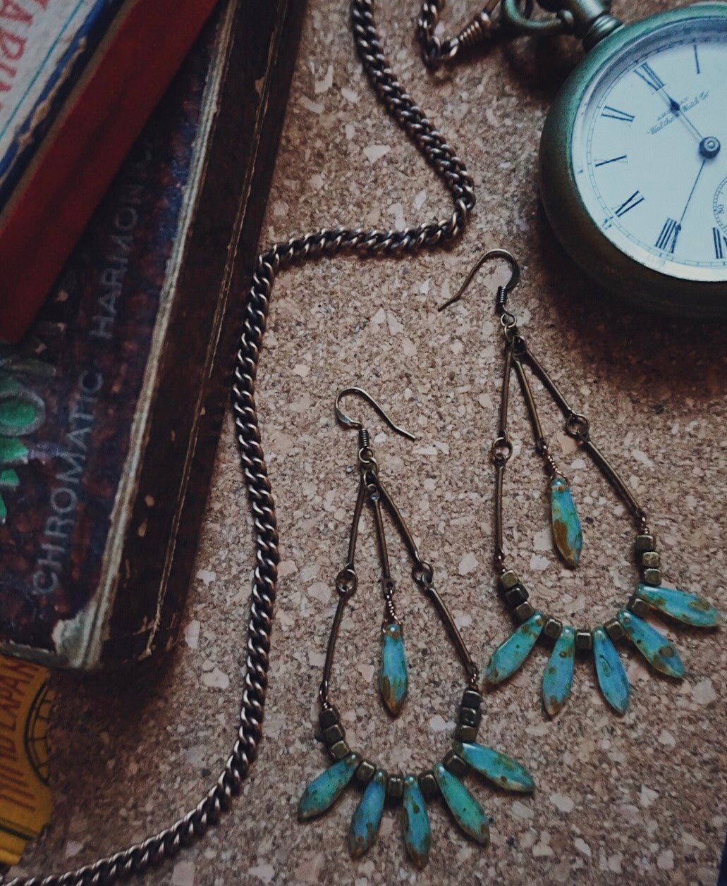 bronze statement earrings, turquoise picasso accents, flat lay product picture