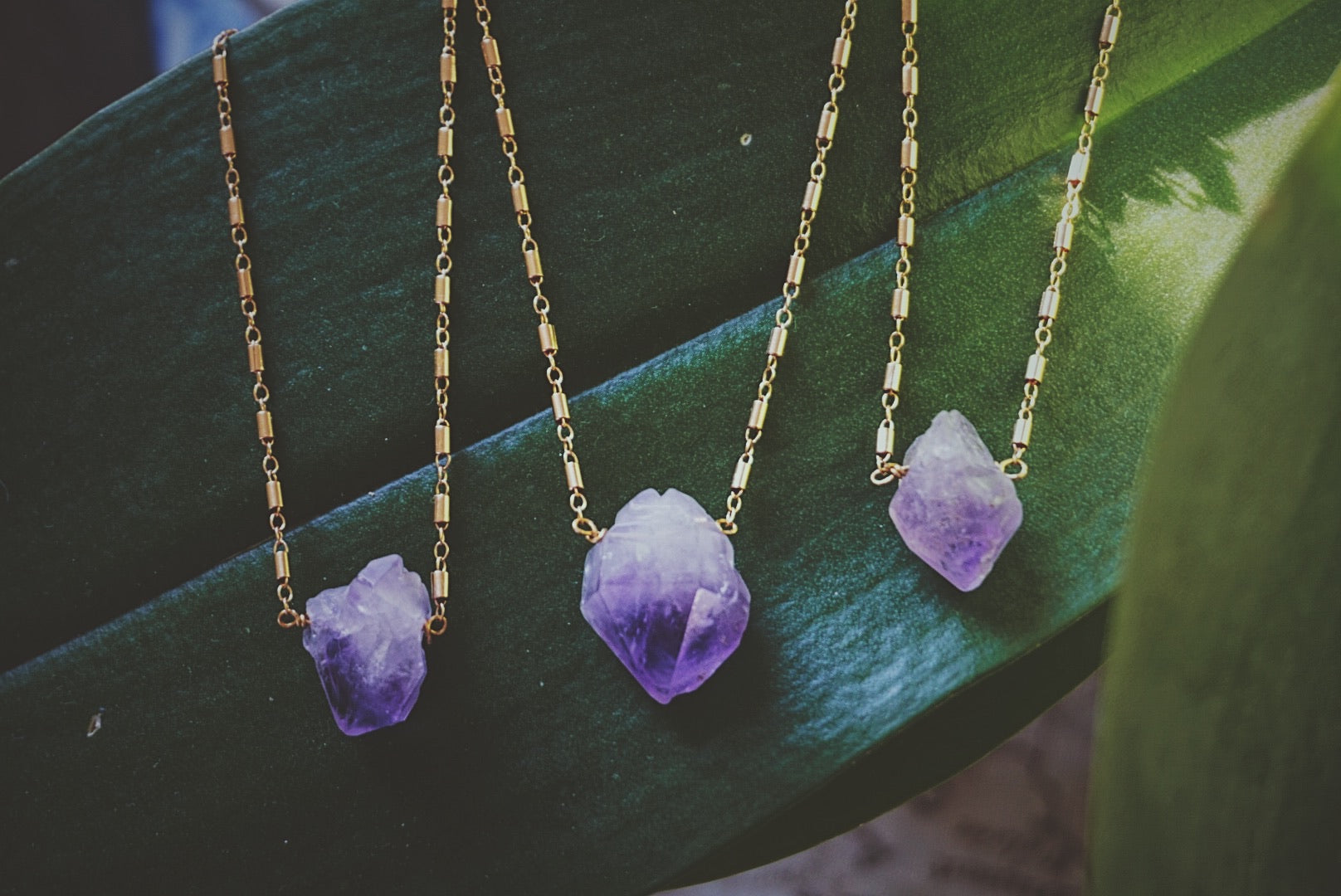 variety of raw amethyst chunks held by gold filled chain, product image